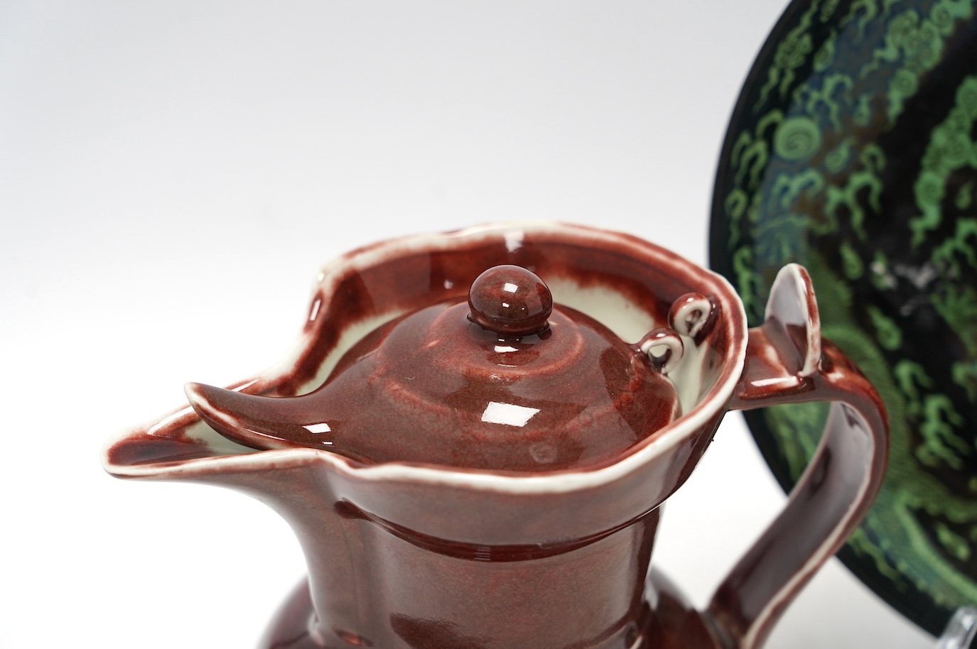 A Chinese famille noire ‘dragon’ dish, 22.5cm diameter, and a Sang de boeuf glaze monk’s cap ewer, Condition - good
